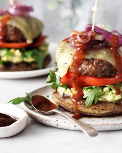 Grilled beef burger on a mushroom bun with avocado and Celebrate Health bbq sauce