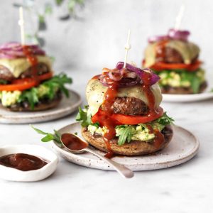 Grilled beef burger on a mushroom bun with avocado and Celebrate Health bbq sauce