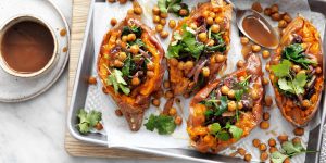 Sweet potatoes stuffed with chick peas served with a bowl of vegan gravy
