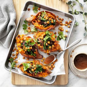 Sweet potatoes stuffed with chick peas served with a bowl of vegan gravy